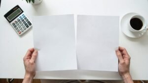 Persona confronta due offerte di prestito stampate alla scrivania