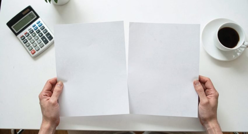 Persona confronta due offerte di prestito stampate alla scrivania